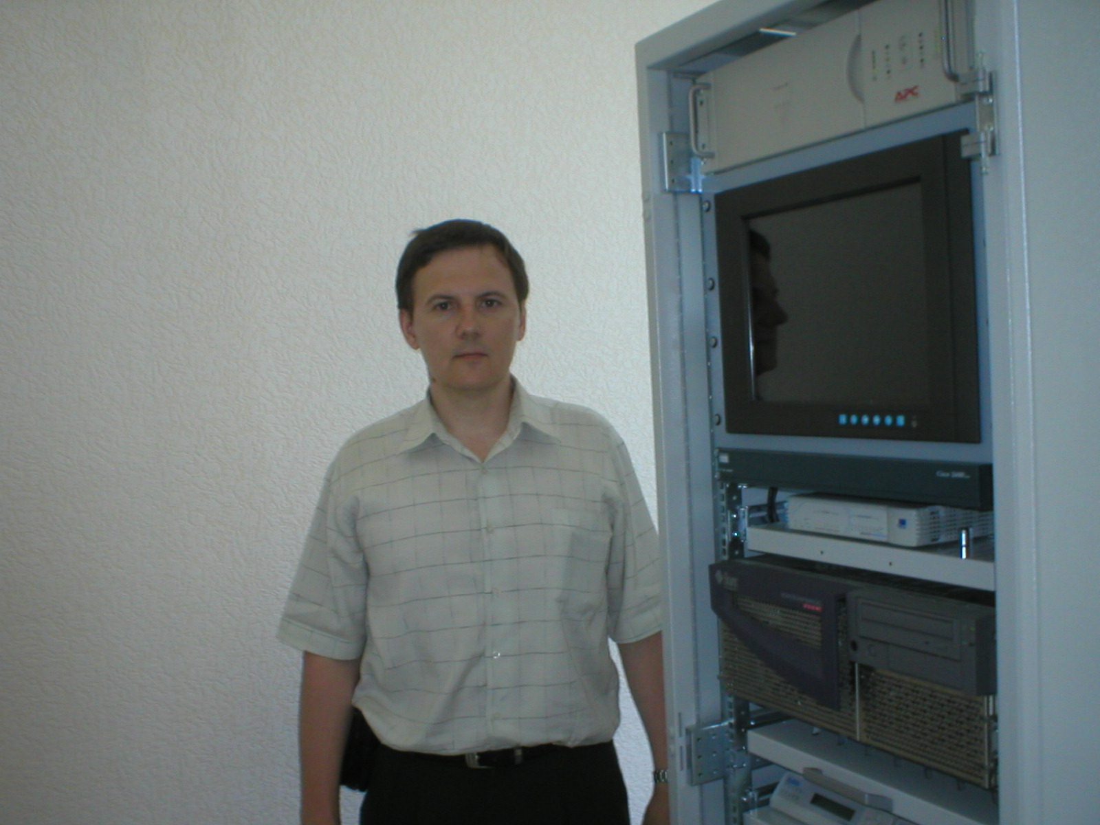 Д-р Андрій, старший науковий співробітник, стоїть поруч з обладнанням станції контролю та корекції в лабораторії навігаційних систем